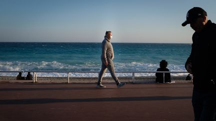 Des passants sur la promenade des Anglais, à Nice (Alpes-Maritimes), le 21 février 2021. (LAURENCE KOURCIA / HANS LUCAS / AFP)