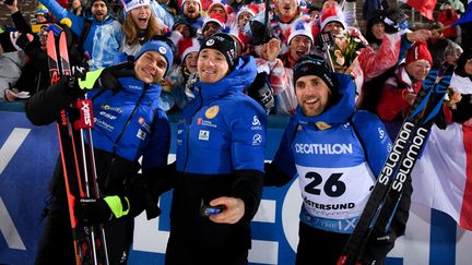 Emilien Jacquelin, Fabien Claude et Simon Desthieux (de gauche à droite) savourent avec les supporters français après le sprint d'Östersund (Suède), dimanche 28 novembre. (ALEXEY FILIPPOV / SPUTNIK via AFP)