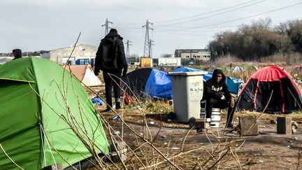 Des migrants dans un campement près du port de Calais, le 18 février 2019. (PHILIPPE HUGUEN / AFP)