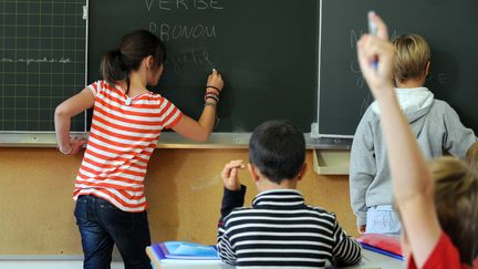 Une fillette &eacute;crit sur le tableau noir d'une classe d'&eacute;cole &agrave;&nbsp;Nantes, le 5 d&eacute;cembre 2011. (FRANK PERRY / AFP)