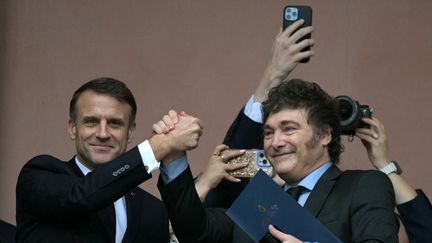 Emmanuel Macron (à gauche) et le président argentin Javier Milei se tiennent la main sur le balcon du palais du gouvernement Casa Rosada après une réunion à Buenos Aires (Argentine), le 17 novembre 2024. (JUAN MABROMATA / AFP)