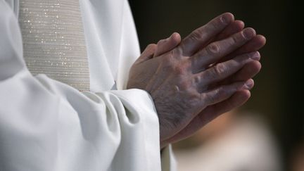 Un prêtre prie, les mains jointes. Photo d'illustration. (FRANCOIS GUILLOT / AFP)