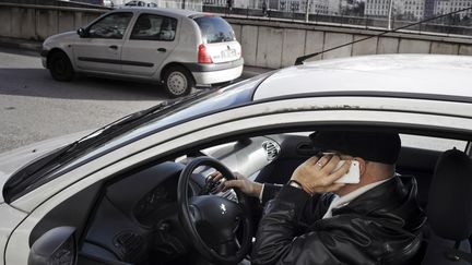 Un homme téléphone au volant, le 4 janvier 2012, à Lyon.&nbsp; (JEAN-PHILIPPE KSIAZEK / AFP)