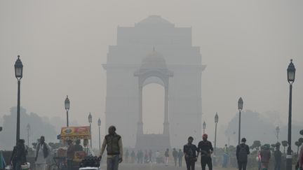 Des Indiens marchant dans le smog autour de la porte de l'Inde à New Delhi le 20 décembre 2017&nbsp; (SAJJAD HUSSAIN / AFP)