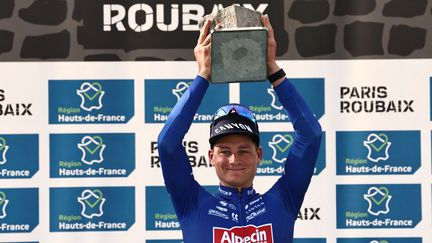 Mathieu van der Poel célèbre sa victoire sur le podium de Paris-Roubaix, le 9 avril 2023. (ANNE-CHRISTINE POUJOULAT / AFP)