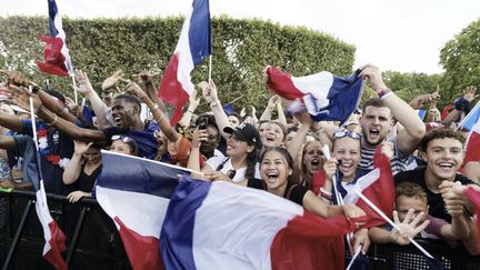 Des supporters fêtent la victoire de la France en Coupe du monde sur l'avenue des Champs-Elysées, à Paris, le 15 juillet 2018.&nbsp; (BERNARD MANIGAULT / CROWDSPARK / AFP)