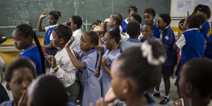 A Soweto, en Afrique du Sud, les élèves s'alignent pour suivre un cours. (GULSHAN KHAN / AFP)