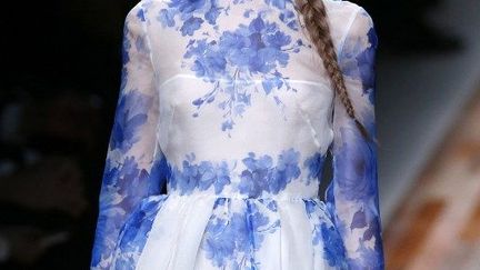 Valentino a présenté une collection toute en grâce et en modernité. Les premiers modèles sont apparues en robes très courtes, sévères, unicolores et petits cols blancs sages d'écolière. Puis les robes se sont allongées, colorées, évasées. Broderies, voiles, dentelles délicates, empiècements multicolores: le duo Maria Grazia Chiuri et Pierpaolo Piccioli, stylistes de la marque depuis 2008, a joué sur les détails pour révéler la féminité des lignes strictes de ses robes, jupes, manteaux, chemisiers et pantalons. Noir profond, jaune ou rose pâle, rouge vif, longue ou courte, en cuir ou en texture tapis, la robe est glorifiée à cette collection.
