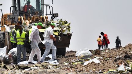 Des enquêteurs sur les lieux du crash, à&nbsp;Hama Quntushele, en Ethiopie, le 14 mars 2019. (TONY KARUMBA / AFP)