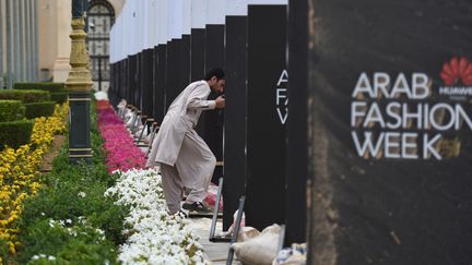 Un ouvrier installe des panneaux avant l'ouverture de la Fashion Week à Riyad, en Arabie saoudite, le 10 avril 2018. (FAYEZ NURELDINE / AFP)