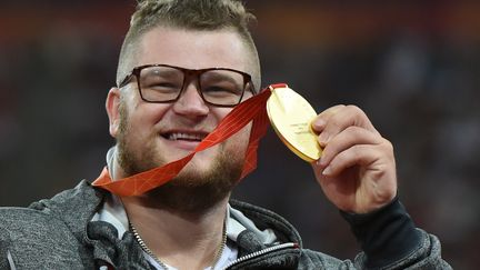 Pawel Fajdek et sa fameuse médaille.  (GREG BAKER / AFP)