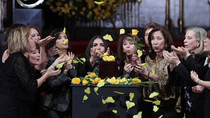 Un groupe de femme rend hommage à Gabriel Garcia Marquez en soufflant des fleurs jaunes au-dessus de son urne, au palais des Beaux-Arts de Mexico (21 avril 2014)
 (Guillermo Granados / Notimex / AFP)