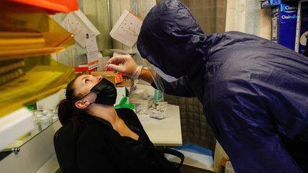 Un employé d'une pharmacie réalise un test antigénique du Covid-19 sur une patiente à Deauville (Calvados), le 4 août 2021. (SAMEER AL-DOUMY / AFP)