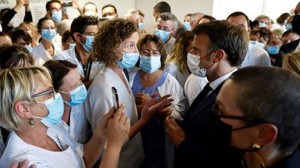 Emmanuel Macron échange avec une soignante lors d'une visite au Centre hospitalier de Cherbourg (Manche), le 31 mai 2022. (SAMEER AL-DOUMY / AFP)