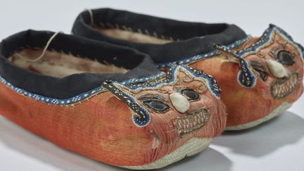 Chaussures pour enfant à tête de tire hutouxie (Chine, milieu du XIXe), Musée des Confluences de Lyon, Dépôt des Oeuvres pontificales missionnaires à Lyon
 (Q. Lafont / musée des Confluences)