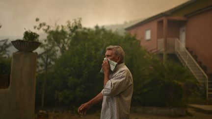 Un homme protège son visage à Torgal, au Portugal, le 18 juin 2017. (PATRICIA DE MELO MOREIRA / AFP)