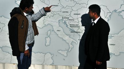 Deux migrants devant une carte de l'Europe à la frontière entre la Grèce et la Macédoine, le 22 février 2016.&nbsp; (SAKIS MITROLIDIS / AFP)