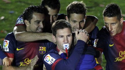 Lionel Messi avec dans ses bras son fils Thiago c&eacute;l&egrave;bre avec d'autres joueurs du FC Barcelone le titre de champion d'Espagne au Camp Nou stadium de Barcelone (Espagne), le 19 mai 2013. (ALBERT GEA / REUTERS)