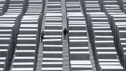 Deux personnes se prom&egrave;nent dans le m&eacute;morial de l'Holocauste recouvert de neige &agrave; Berlin (Allemagne), le 27 janvier 2014. (MARKUS SCHREIBER / AP / SIPA)