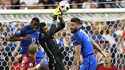 Paul Pogba et Olivier Giroud aux prises avec le gardien de but portugais Rui Patricio, lors de la finale de l'Euro, le 10 juillet 2016.&nbsp; (MARTIN BUREAU / AFP)