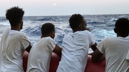 Des migrants soudanais à bord du navire humanitaire Ocean Viking, le 14 août 2019 en mer Méditerranée (ANNE CHAON / AFP)