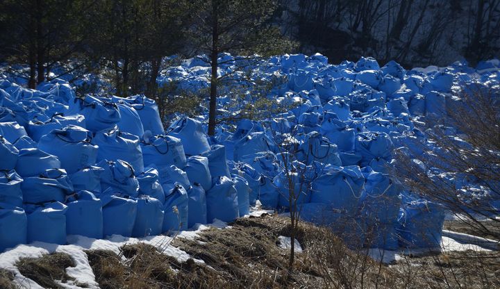 Des sacs poubelles remplis de d&eacute;chets radioactifs sont stock&eacute;s sur le bord d'une route, pr&egrave;s du village de Kawauchi, dans la pr&eacute;fecture de Fukushima, le 5 mars 2013. (AKIO KON / BLOOMBERG / GETTY IMAGES)