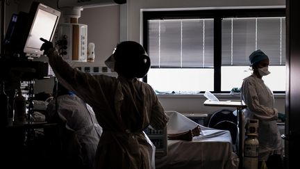 Des soignants dans la chambre d'un patient du Covid-19, dans le service de réanimation de l'hôpital de La Croix-Rousse, à Lyon (Rhône) le 15 septembre 2020 (JEFF PACHOUD / AFP)