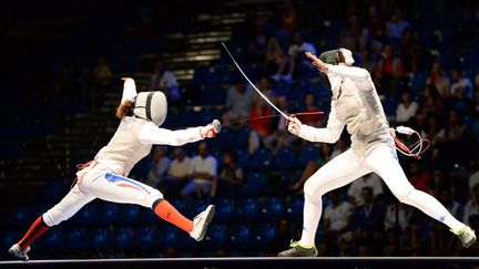 La Fran&ccedil;aise Ysaora Thibus (&agrave; gauche) affronte l'Italienne Elisa di Francisca pendant la finale de l'&eacute;preuve par &eacute;quipes dames de fleuret, au championnat du monde d'escrime, &agrave; Budapest, samedi&nbsp;10 ao&ucirc;t 2013. (ATTILA KISBENEDEK / AFP)