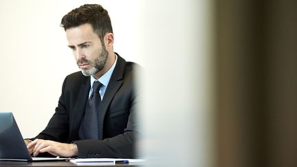 A man and a computer in an office.  (ERIC AUDRAS / MAXPPP)