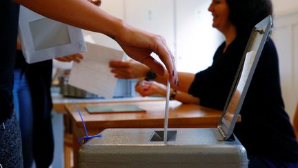 Une femme vote lors d'une consultation sur le revenu de base universelle à Bern, en Suisse, le 5 juin 2016. (RUBEN SPRICH / REUTERS)