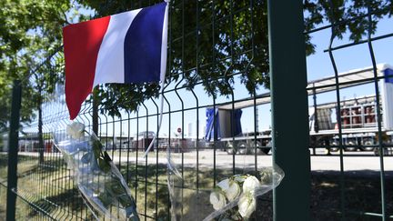 Des fleurs et un drapeau &agrave; l'endroit o&ugrave; la t&ecirc;te de la victime de l'attentat de Saint-Quentin-Fallavier (Is&egrave;re) a &eacute;t&eacute; retrouv&eacute;e, le 28 juin 2015. (PHILIPPE DESMAZES / AFP)