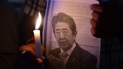 Des membres du centre d'information et d'étude du Japon organisent une veillée aux chandelles pour rendre hommage à feu l'ancien Premier ministre japonais Shinzo Abe, le 9juillet 2022. (SAM PANTHAKY / AFP)