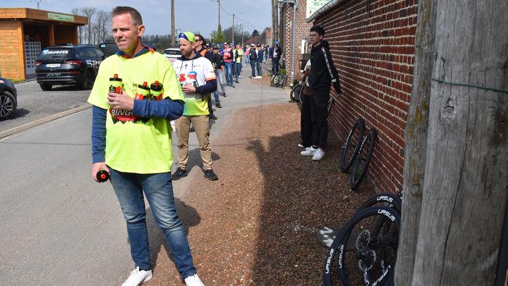 Une longue file d'assistants attend le passage des coureurs à la sortie du secteur 24 de Paris-Roubaix, avec des bidons mais aussi des pneus. (Hortense Leblanc)