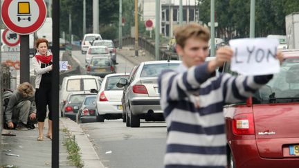 Des personnes font de l'autostop porte d'Orléans, à Paris, à l'entrée de l'autoroute A6. (EMILIEN CANCET / AFP)