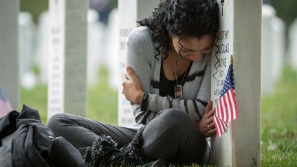 Au cimeti&egrave;re militaire d'Arlington (Virginie, Etats-Unis), une veuve pleure sur la tombe de son &eacute;poux tu&eacute; en Afghanistan en 2011, le 16 octobre 2013. (MANUEL BALCE CENATA / AP / SIPA)