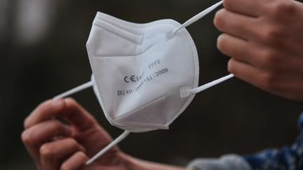 Une femme tient un masque&nbsp;FFP2 le 28 décembre 2021, à L'Aquila (Italie). (LORENZO DI COLA / NURPHOTO / AFP)