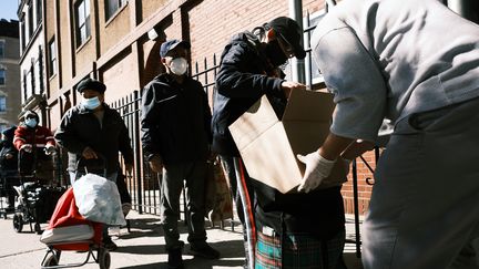 Les gens reçoivent de la nourriture à l'église chrétienne de Thessalonique lors d'une distribution le 17 octobre 2020 à New York. (SPENCER PLATT / GETTY IMAGES NORTH AMERICA / AFP)