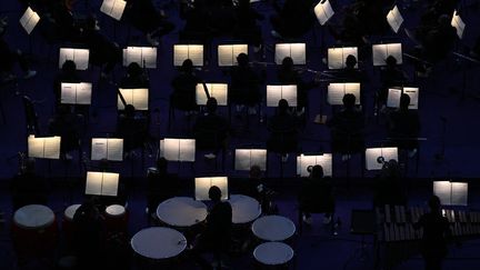 Après un saut de quelques kilomètres, la cérémonie prend ses quartiers au Stade de France avec, pour débuter, une prestation de l'orchestre symphonique Divertimento qui interprète notamment la Marseillaise. (MOHD RASFAN / AFP)