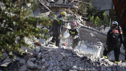 Les pompiers poursuivent leurs recherches, le 1er septembre 2014,&nbsp;dans les d&eacute;combres de l'immeuble qui s'est effondr&eacute; &agrave; Rosny-sous-Bois (Seine-Saint-Denis). (MARTIN BUREAU / AFP)