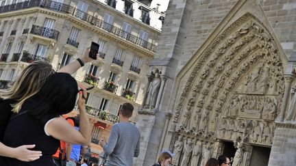 Des touristes devant la cathédrale Notre-Dame de Paris, le 28 juin 2017. (XAVIER VILA / SIPA)