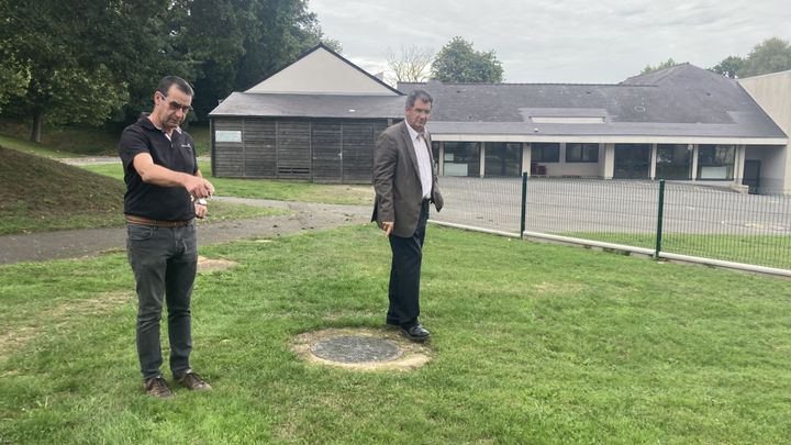 Le responsable technique de la commune du Mené (Côtes-d'Armor), Denis Bazin (à gauche), et le maire Gérard Daboudet, observent le système de chauffage géothermique à l'école primaire du Collinée.&nbsp; (MATHILDE GRACIA/ FRANCEINFO)