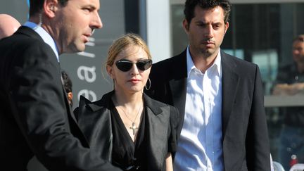 Madonna arrive à Marseille avec ses gardes du corps pour rencontrer les ouvriers blessés dans l'effondrement du toit de la scène où elle devait chanter, au stade Vélodrome (19 juillet 2009) (TSCHAEN/SIPA)