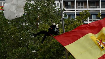 Un parachutiste heurte un lampadaire lors d'un&nbsp;défilé militaire à Madrid, le 12 octobre 2019. (OSCAR DEL POZO / AFP)