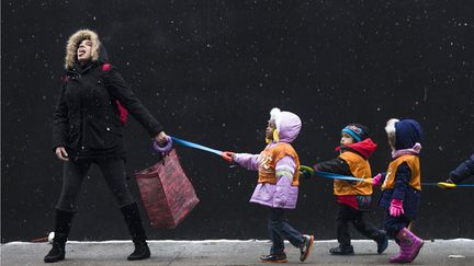 Une institutrice s'amuse avec les flocons de neige en amenant ses &eacute;l&egrave;ves &agrave; la biblioth&egrave;que &agrave; New York (Etats-Unis), le 10 janvier 2014. (ADREES LATIF / REUTERS)