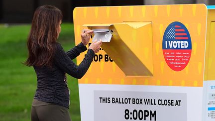 Une femme dépose son bulletin de vote dans une urne officielle à l'extérieur du bureau de l'état civil du comté de Los Angeles à Norwalk, en Californie, le 14 septembre 2021. (FREDERIC J. BROWN / AFP)