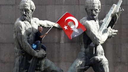 Un manifestant agite le drapeau national perch&eacute; sur un monument dans le centre d'Ankara (Turquie), le 2 juin 2013. (UMIT BEKTAS / REUTERS)