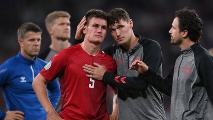 Joakim Maehle (en rouge) consolé par ses coéquipiers après l'élimination du Danemark en demi-finale de l'Euro 2021 par l'Angleterre mercredi 7 juillet à Wembley. (LAURENCE GRIFFITHS / AFP)