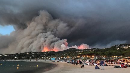 Des personnes évacuées à cause de l'incendie de Bormes-les-Mimosas trouvent refugent sur la plage, le 26 juillet 2017, dans le Var.&nbsp; (MARION LEFLOUR / AFP)