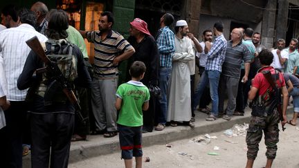 En Syrie, à Alep, ici&nbsp;en juillet 2016, des habitants d'un quartier rebelle dans une file d'attente pour acheter du pain (ABDALRHMAN ISMAIL / REUTERS)