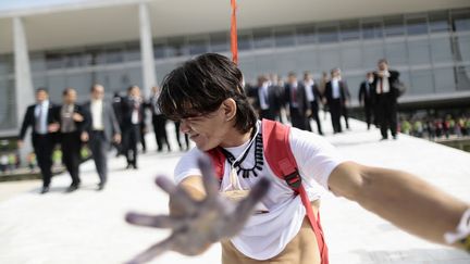 Un manifestant indien s'enfuit apr&egrave;s avoir &eacute;t&eacute; asperg&eacute; de gaz lacrymog&egrave;ne par des agents de s&eacute;curit&eacute; devant le&nbsp;palais pr&eacute;sidentiel du Planalto &agrave; Brasilia (Br&eacute;sil), le 4 d&eacute;cembre 2013. (UESLEI MARCELINO / REUTERS)